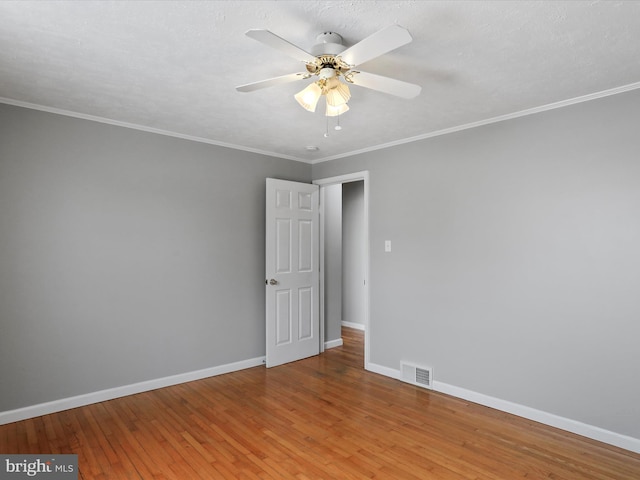 spare room featuring a textured ceiling, ceiling fan, wood-type flooring, and ornamental molding