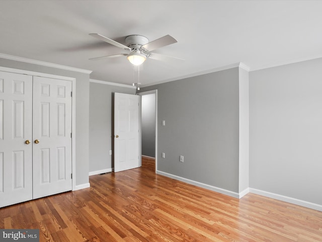 unfurnished bedroom with ceiling fan, light hardwood / wood-style floors, crown molding, and a closet