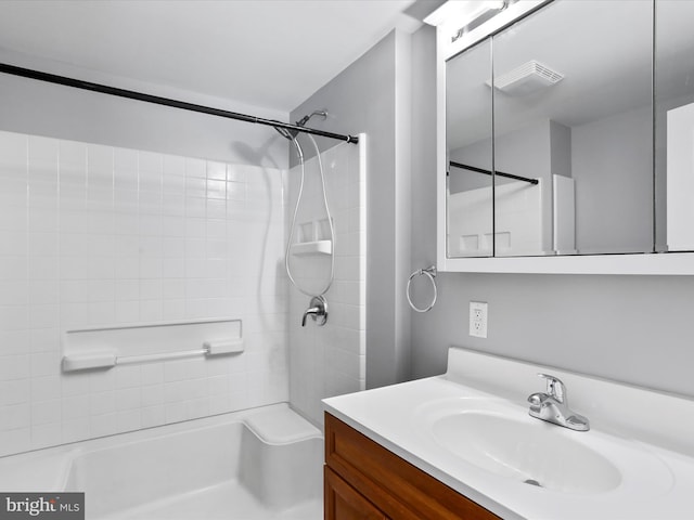 bathroom featuring vanity and tiled shower / bath