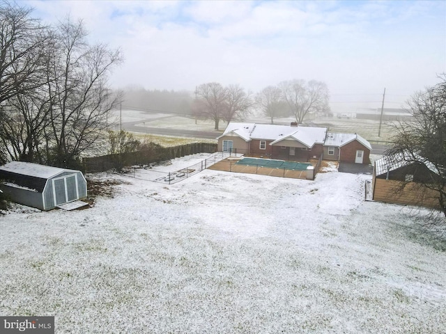 snowy yard with an outdoor structure and a covered pool