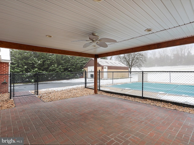 view of patio featuring ceiling fan, tennis court, and a water view