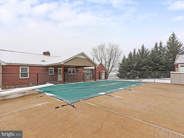 view of swimming pool featuring a diving board and a patio