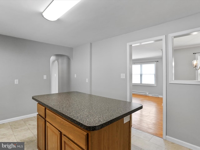 kitchen with light hardwood / wood-style floors, a kitchen island, and a baseboard heating unit