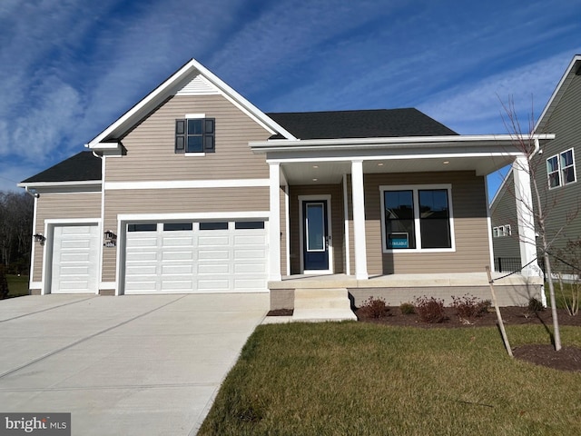 view of front facade featuring a front yard, a porch, and a garage