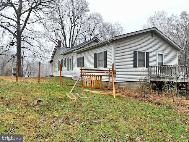 view of side of property with a lawn and a deck