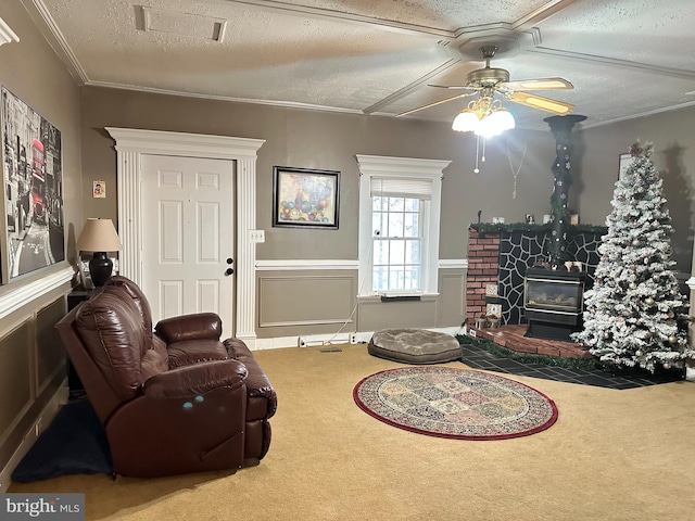 sitting room featuring carpet, a wood stove, ceiling fan, ornamental molding, and a textured ceiling