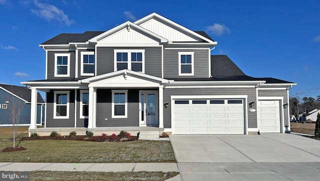 view of front of property featuring a front lawn, covered porch, and a garage