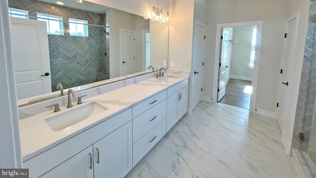 bathroom featuring a shower with door and vanity