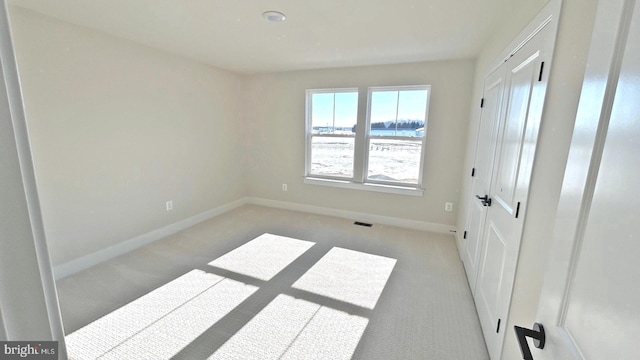 unfurnished bedroom featuring light carpet