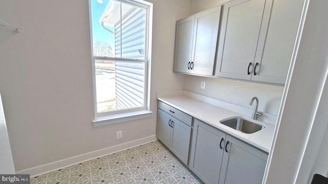 kitchen with gray cabinets, light tile patterned flooring, and sink