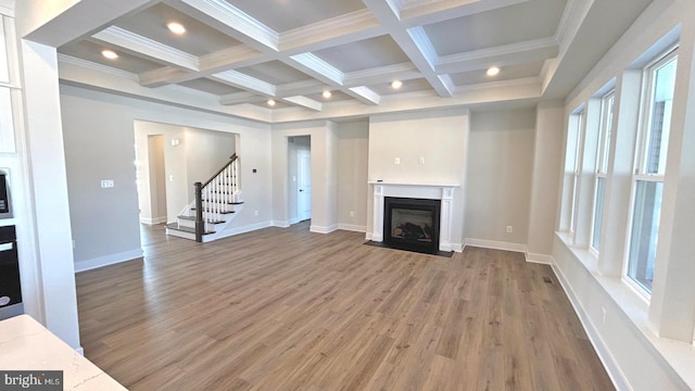 unfurnished living room featuring ornamental molding, wood-type flooring, beam ceiling, and coffered ceiling