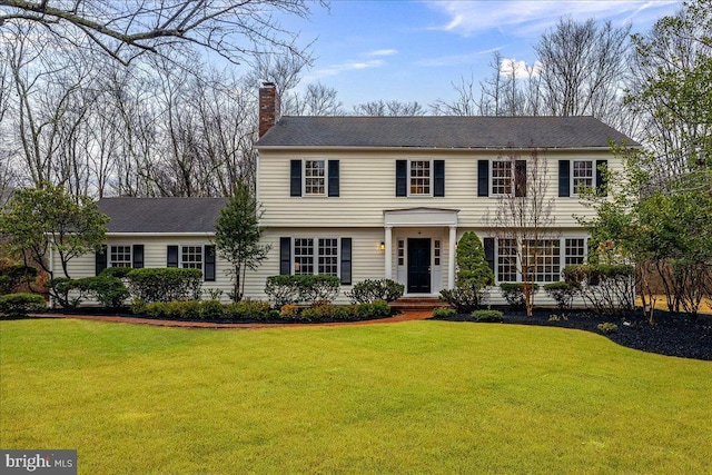 colonial house featuring a front lawn