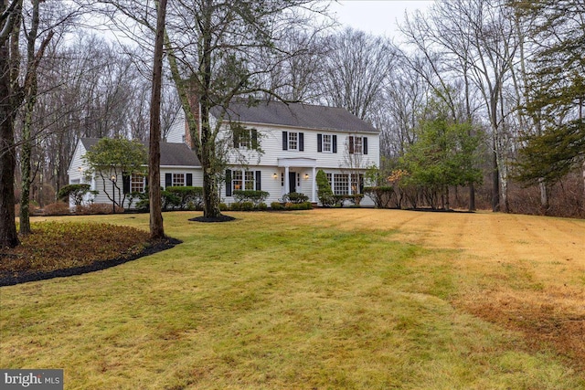 colonial-style house featuring a front yard