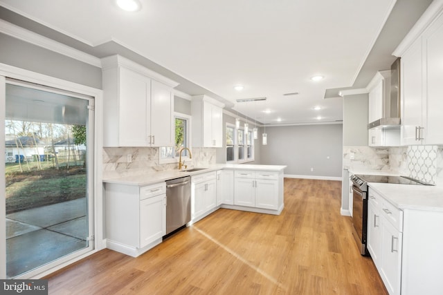 kitchen with white cabinetry, sink, wall chimney exhaust hood, appliances with stainless steel finishes, and light wood-type flooring