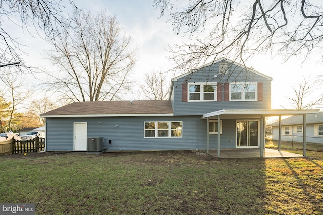 rear view of house with central air condition unit, a yard, and a patio