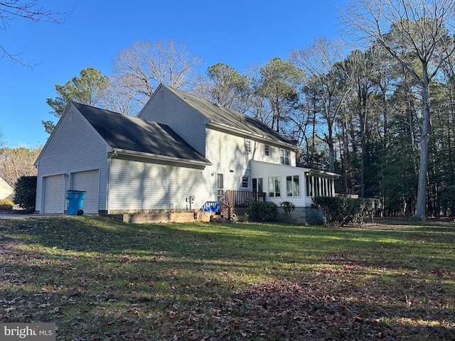 view of property exterior featuring a lawn, a sunroom, a garage, and a deck