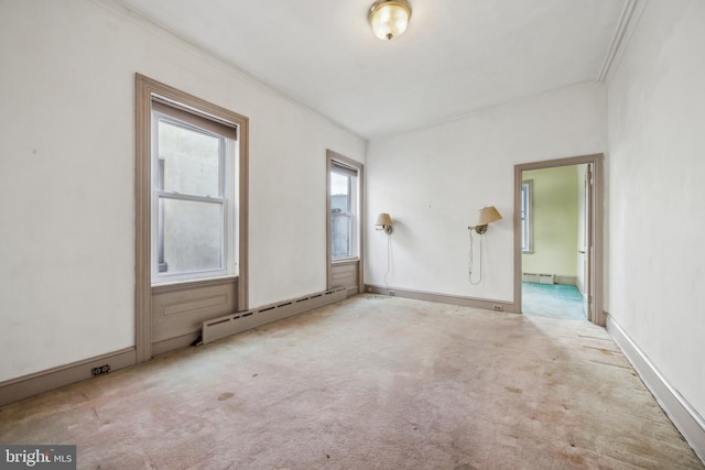 empty room with light carpet, ornamental molding, and a baseboard heating unit