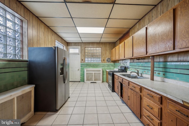 kitchen with stainless steel fridge, a paneled ceiling, sink, radiator heating unit, and black electric range oven