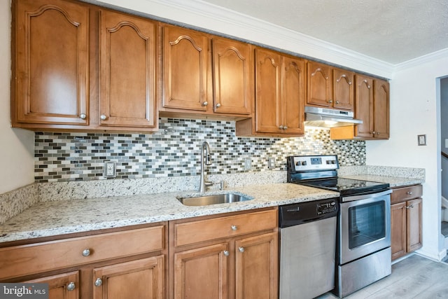 kitchen featuring backsplash, sink, light hardwood / wood-style flooring, light stone countertops, and appliances with stainless steel finishes