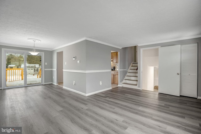 unfurnished living room featuring ornamental molding, a textured ceiling, and light hardwood / wood-style flooring