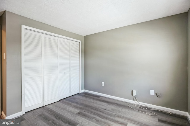 unfurnished bedroom with wood-type flooring and a closet