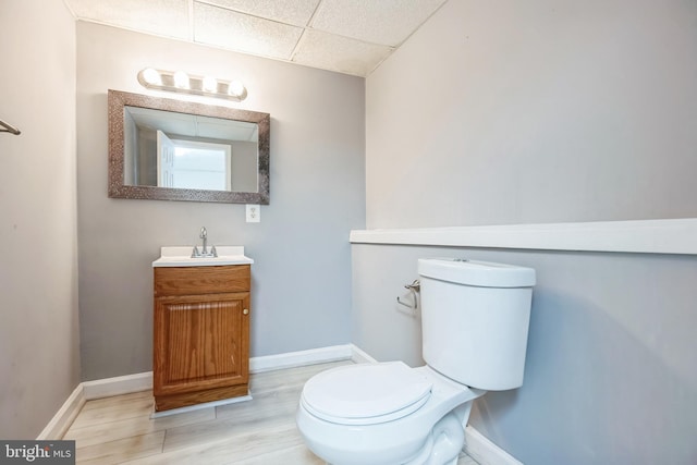 bathroom featuring a paneled ceiling, vanity, toilet, and hardwood / wood-style flooring