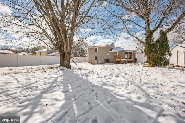 yard layered in snow with a wooden deck