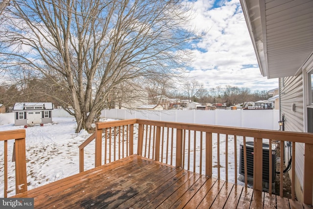 snow covered deck featuring cooling unit and an outdoor structure