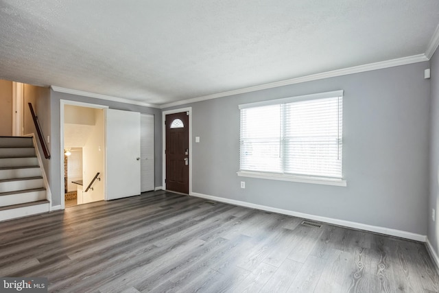 entrance foyer with wood-type flooring, a textured ceiling, and crown molding