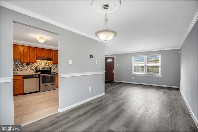 kitchen with backsplash, crown molding, light hardwood / wood-style flooring, and stainless steel appliances