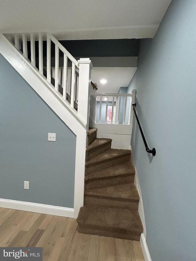 stairway with hardwood / wood-style flooring