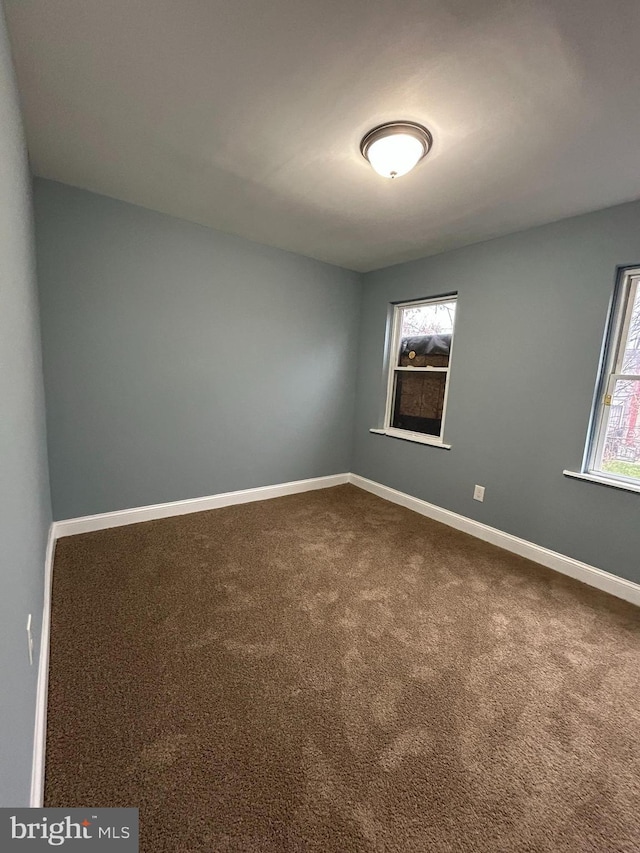 carpeted empty room featuring plenty of natural light