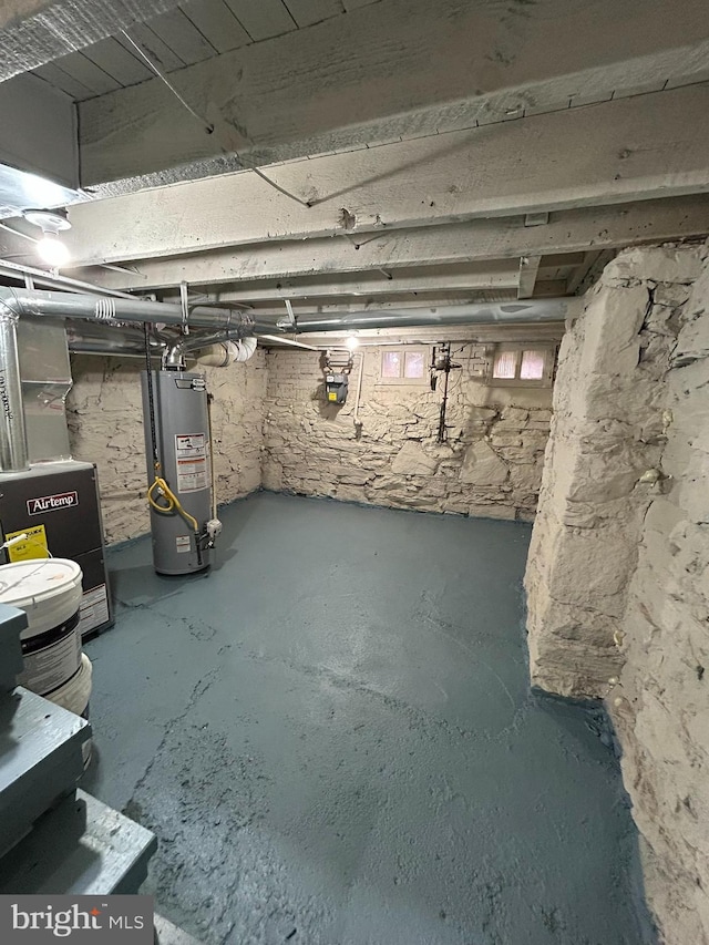 basement featuring heating unit and water heater