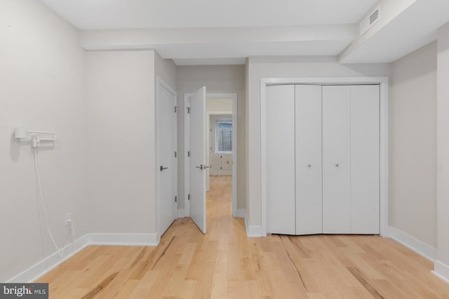 unfurnished bedroom featuring light hardwood / wood-style floors and a closet