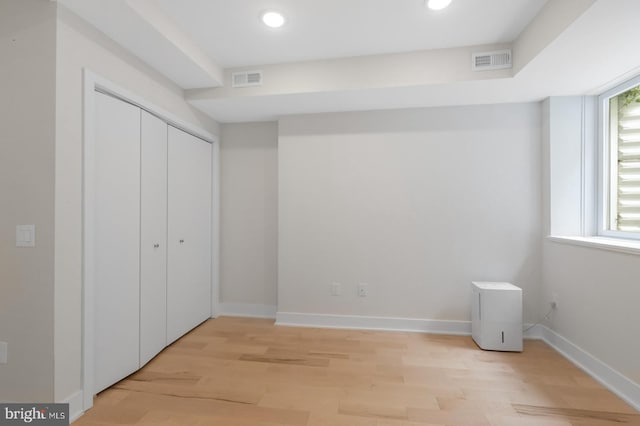 unfurnished bedroom featuring light hardwood / wood-style flooring and a closet