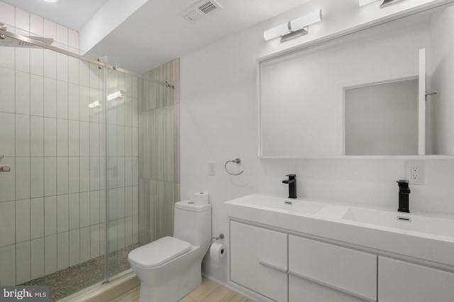 bathroom featuring hardwood / wood-style floors, vanity, toilet, and walk in shower