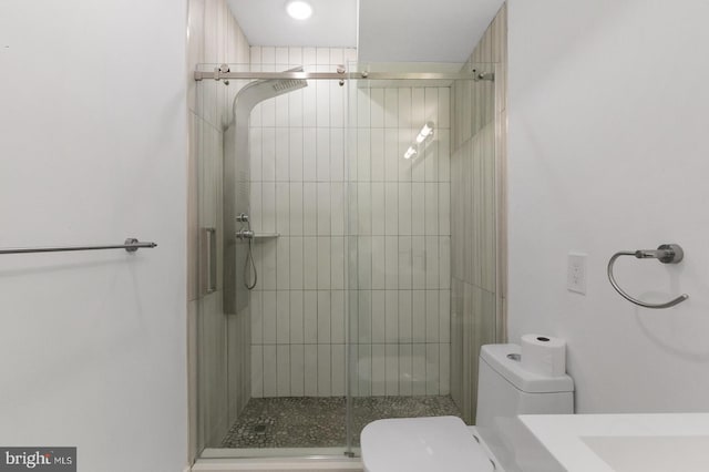 bathroom featuring toilet and a shower with door