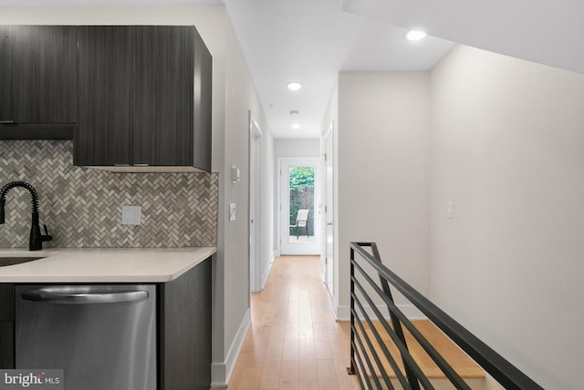 kitchen featuring dishwasher, light wood-type flooring, backsplash, and sink