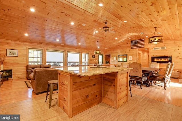 kitchen featuring light stone counters, wood ceiling, lofted ceiling, and light hardwood / wood-style floors