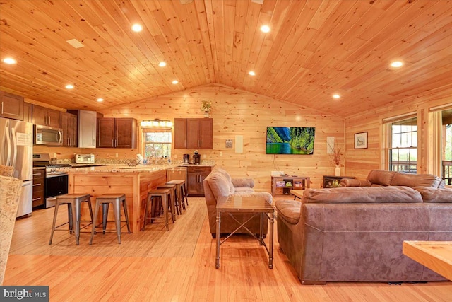 living room with wooden walls, wood ceiling, lofted ceiling, and light wood-type flooring