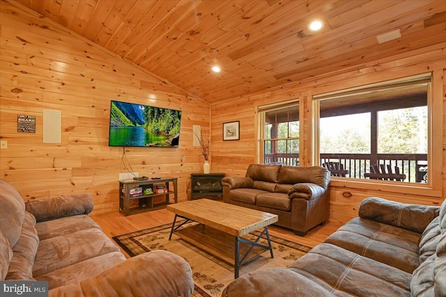 living room featuring light wood-type flooring, wood ceiling, a wood stove, lofted ceiling, and wood walls