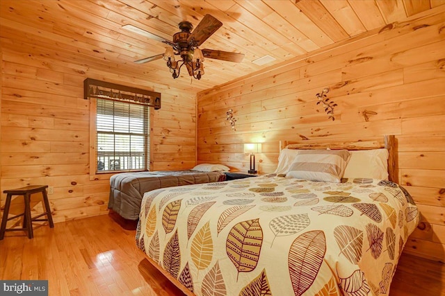 bedroom with wooden walls, ceiling fan, wooden ceiling, and light wood-type flooring