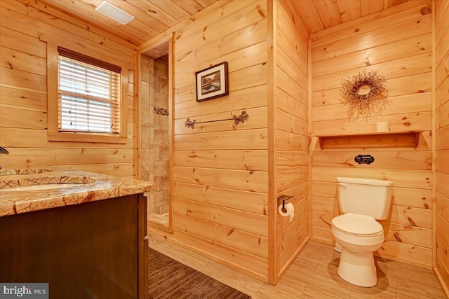 bathroom featuring hardwood / wood-style flooring, vanity, wooden ceiling, and wooden walls