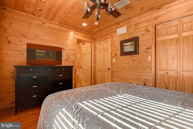 bedroom with ceiling fan, wooden walls, wood-type flooring, and wooden ceiling