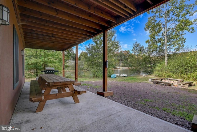 view of patio with a water view and a grill