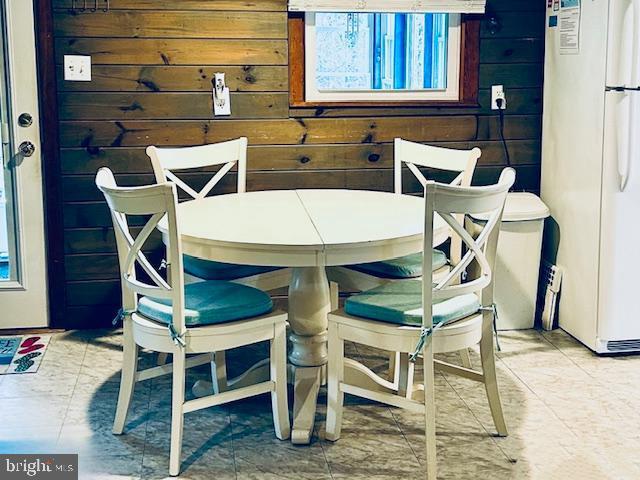 dining area featuring wooden walls