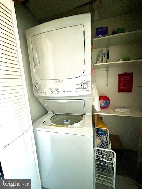 washroom featuring stacked washer / dryer