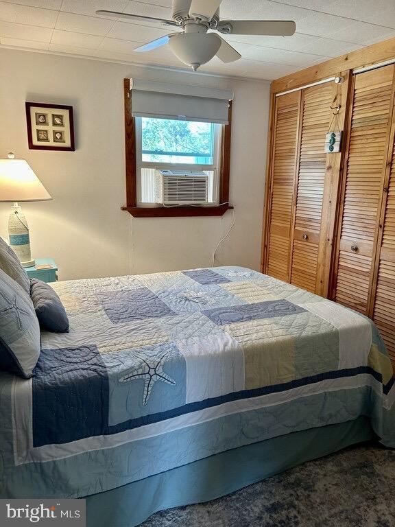 carpeted bedroom featuring ceiling fan and cooling unit