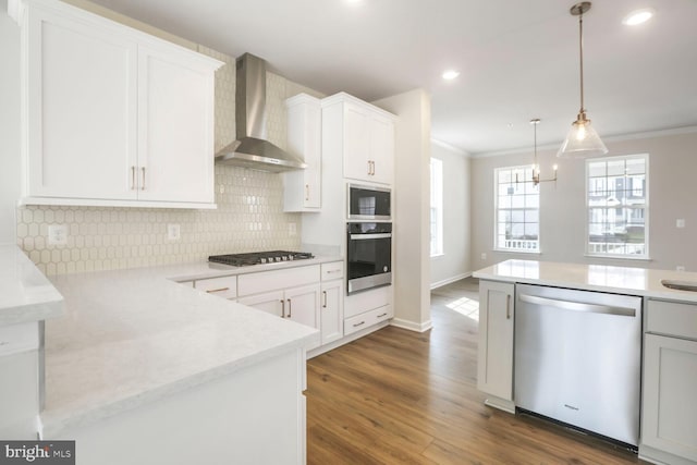 kitchen with dark wood finished floors, decorative backsplash, wall chimney exhaust hood, appliances with stainless steel finishes, and crown molding