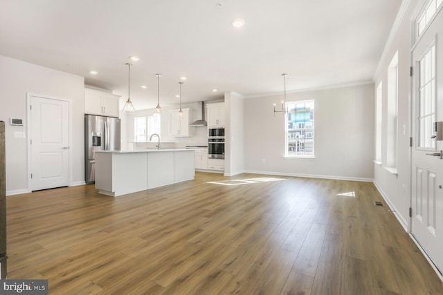 unfurnished living room with recessed lighting, dark wood-style flooring, a sink, and baseboards